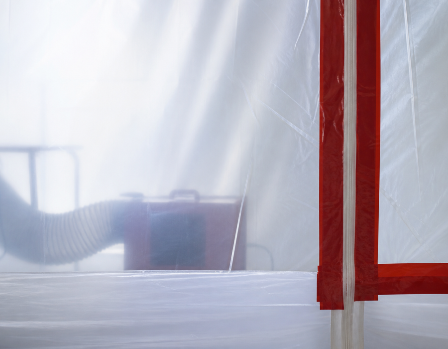 Worker in protective equipment inside containment sheeting